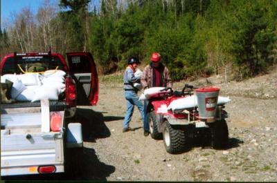 Jeff Johnston pouring seed into the hopper on his 4wheeler.